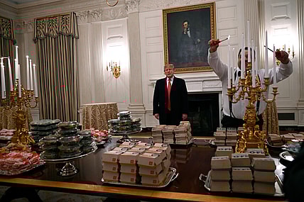 n this Jan. 14, 2019 photo, President Donald Trump talks to the media about the table full of fast food in the State Dining Room of the White House in Washington, for the reception for the Clemson Tigers. The partial government shutdown is hitting home for President Trump in a very personal way. He lives in government-run housing, after all. Just 21 of the roughly 80 people who help care for the White House _ from butlers to electricians to chefs _ are reporting to work. The rest have been furloughed. (AP Photo/Susan Walsh) thegrio.com