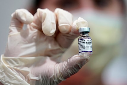 A healthcare worker holds a vial of the Pfizer COVID-19 vaccine