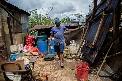 A man checks damages in a house near the highway