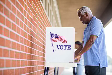 A man stands at a voting booth