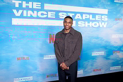 Rapper Vince Staples wearing a gray shirt and navy pants