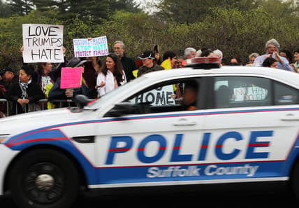 CENTRAL ISLIP, NY - APRIL 28: Police pass a group of protesters outside of the venue where Attorney General Jeff Sessions was to speak to local, state and federal law enforcement about a recent spate of gang related killings on April 28, 2017 in Central Islip, New York. Since the start of the school year the violent street gang MS-13 has been blamed for 11 deaths of mostly young people in residential Brentwood and neighboring Central Islip. The bodies have often been found in wooded areas and vacant lots. Sessions, who takes a tough stance on law and order, vowed to bring the gang leaders to justice. (Photo by Spencer Platt/Getty Images) thegrio.com