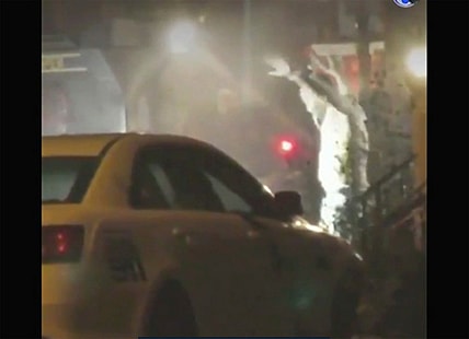In this image from video taken by Bill Trenwith on Wednesday, Aug. 14, 2019, a man exits a building with hands up in Philadelphia, Pennsylvania. A gunman who opened fire on police Wednesday as they were serving a drug warrant in Philadelphia, wounding six officers and triggering a standoff that extended into the night, is in police custody, authorities said. (Bill Trenwith via AP) thegrio.com