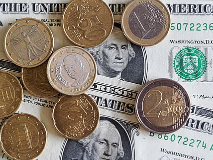 Coins and dollars show the comparison of the euro to the dollar today
