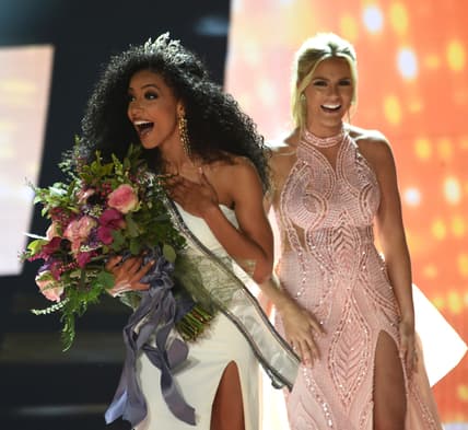 Miss North Carolina Cheslie Kryst, left, gets crowned by last year's winner Sarah Rose Summers, right, after winning the 2019 Miss USA final competition in the Grand Theatre in the Grand Sierra Resort in Reno, Nev., on Thursday, May 2, 2019. Kryst, a 27-year-old lawyer from North Carolina who represents some prison inmates for free, won the 2019 Miss USA title Thursday night in a diverse field that included teachers, nurses and members of the military. (Jason Bean/The Reno Gazette-Journal via AP) thegrio.com