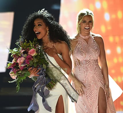 Miss North Carolina Cheslie Kryst, left, gets crowned by last year's winner Sarah Rose Summers, right, after winning the 2019 Miss USA final competition in the Grand Theatre in the Grand Sierra Resort in Reno, Nev., on Thursday, May 2, 2019. Kryst, a 27-year-old lawyer from North Carolina who represents some prison inmates for free, won the 2019 Miss USA title Thursday night in a diverse field that included teachers, nurses and members of the military. (Jason Bean/The Reno Gazette-Journal via AP) thegrio.com