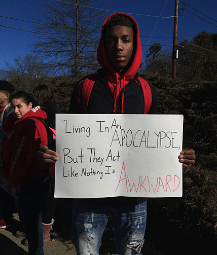 Calvin Bridges, a senior at South Hadley High School, held a sign during the walkout. thegrio.com