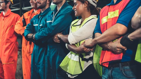 A group of workers with arms crossed holding hands