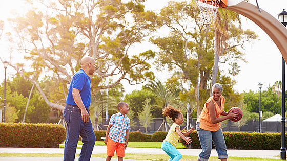 Grandparents And Grandchildren Playing Basketball Together Smiling