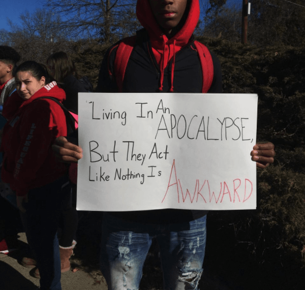 Calvin Bridges, a senior at South Hadley High School, held a sign during the walkout. thegrio.com