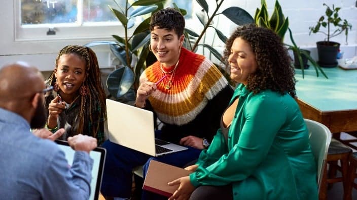 A group of people with books and laptops