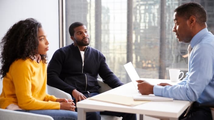 Couple Meeting With Male Financial Advisor Relationship Counsellor In Office