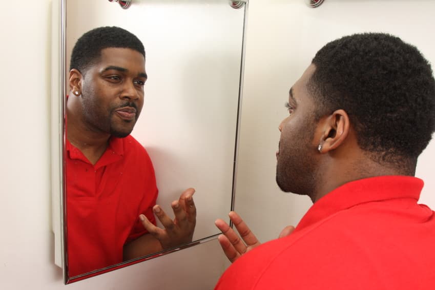 man looking at himself in the mirror thegrio.com