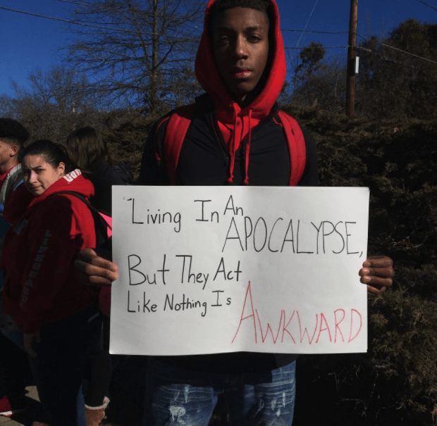 Calvin Bridges, a senior at South Hadley High School, held a sign during the walkout. thegrio.com