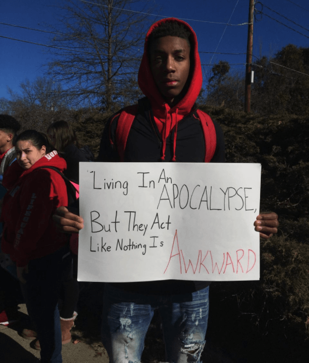 Calvin Bridges, a senior at South Hadley High School, held a sign during the walkout. thegrio.com