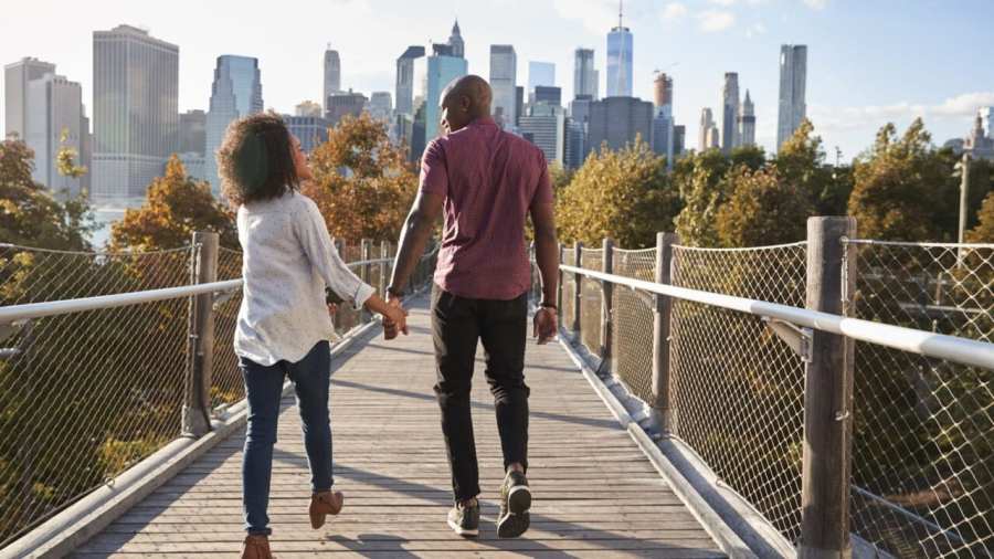 Couple Visiting New York With Manhattan Skyline In Background thegrio.com