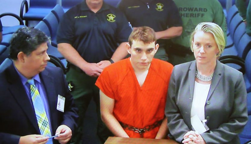 FORT LAUDERDALE, FL - FEBRUARY 15: Nikolas Cruz, 19, a former student at Marjory Stoneman Douglas High School in Parkland, Florida, where he allegedly killed 17 people, is seen on a closed circuit television screen during a bond hearing in front of Broward Judge Kim Mollica at the Broward County Courthouse.(Photo by Susan Stocker - Pool/Getty Images) thegrio.com