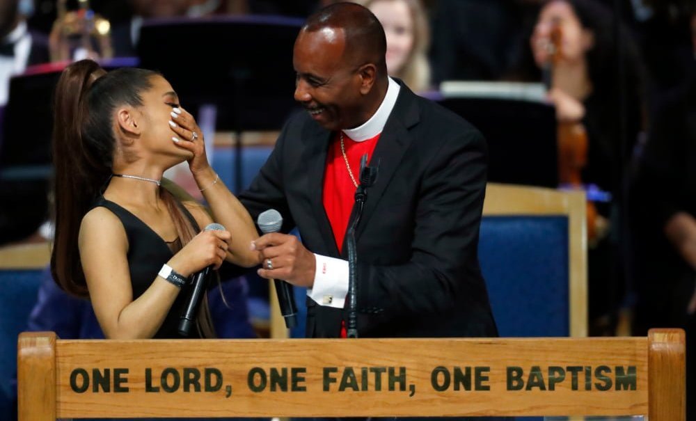 Ariana Grande, left, laughs with Bishop Charles H. Ellis during the funeral service for Aretha Franklin at Greater Grace Temple, Friday, Aug. 31, 2018, in Detroit. Franklin died Aug. 16, 2018 of pancreatic cancer at the age of 76. (AP Photo/Paul Sancya)