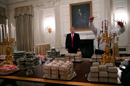 n this Jan. 14, 2019 photo, President Donald Trump talks to the media about the table full of fast food in the State Dining Room of the White House in Washington, for the reception for the Clemson Tigers. The partial government shutdown is hitting home for President Trump in a very personal way. He lives in government-run housing, after all. Just 21 of the roughly 80 people who help care for the White House _ from butlers to electricians to chefs _ are reporting to work. The rest have been furloughed. (AP Photo/Susan Walsh) thegrio.com