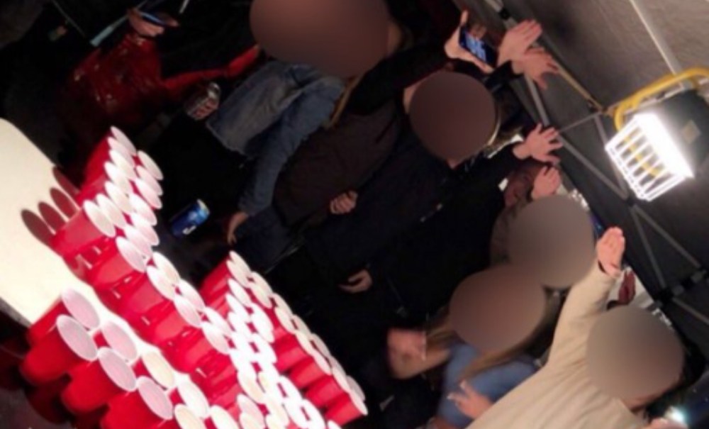 This image from Twitter shows Newport-Mesa students toasting over a swastika made from red plastic cups. The "ultimate rage" banner over the image was added by a social media user. (Twitter) thegrio.com