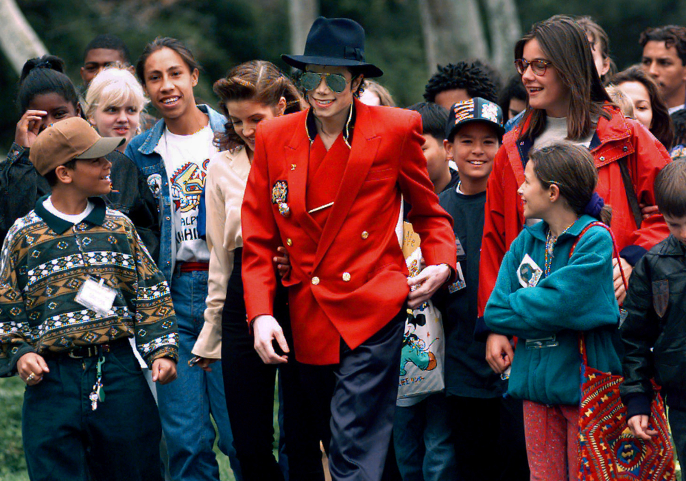 In this April 18, 1995, file photo, pop star Michael Jackson and Lisa Marie Presley, behind him at left, walk with children that were invited guests at his Neverland Ranch home in Santa Ynez, Calif. The co-executor of Jackson's estate says he's confident the late superstar's supporters will be able to protect his legacy and brand in the wake of HBO’s "Leaving Neverland," a documentary detailing allegations of sexual abuse. (AP Photo/Mark J. Terrill, File) thegrio.com