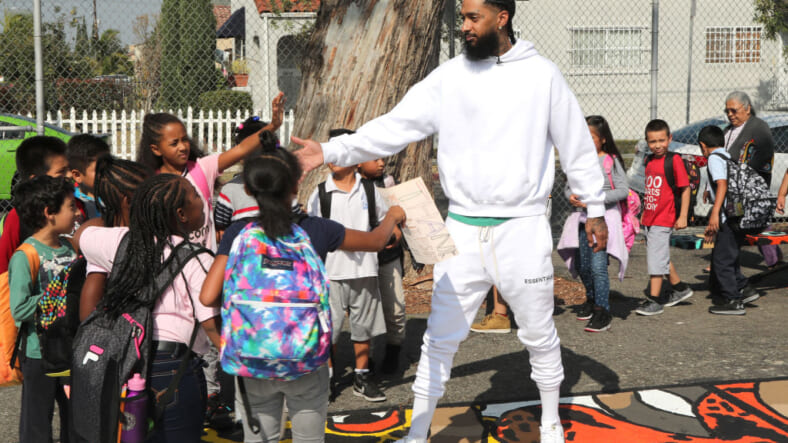 LOS ANGELES, CA - OCTOBER 22: Nipsey Hussle greets kids at the Nipsey Hussle x PUMA Hoops Basketball Court Refurbishment Reveal Event on October 22, 2018 in Los Angeles, California. (Photo by Jerritt Clark/Getty Images for PUMA) thegrio.com