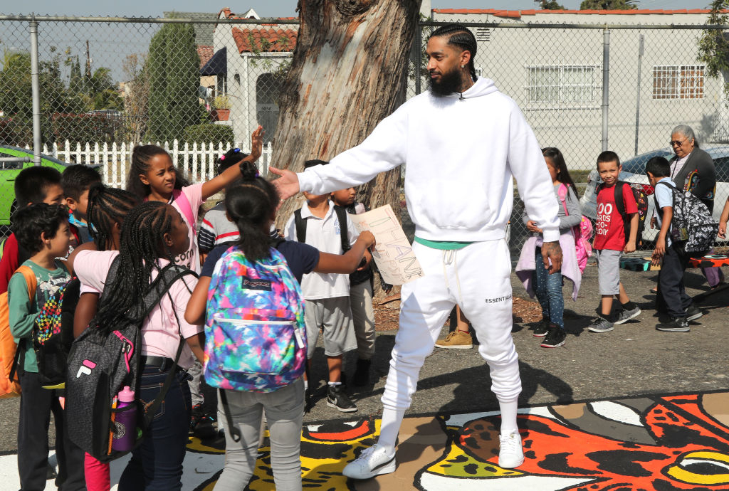 LOS ANGELES, CA - OCTOBER 22: Nipsey Hussle greets kids at the Nipsey Hussle x PUMA Hoops Basketball Court Refurbishment Reveal Event on October 22, 2018 in Los Angeles, California. (Photo by Jerritt Clark/Getty Images for PUMA) thegrio.com