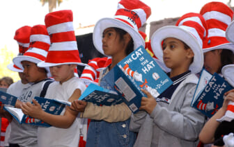 Children read from "The Cat in the Hat" book at a ceremony honoring the late children's book author Dr. Seuss (Theodore Geisel) with a star on the Hollywood Walk of Fame on March 11, 2004 in Hollywood , California. (Photo by Vince Bucci/Getty Images) thegrio.com