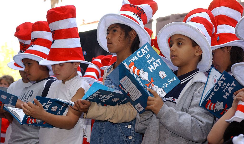 Children read from "The Cat in the Hat" book at a ceremony honoring the late children's book author Dr. Seuss (Theodore Geisel) with a star on the Hollywood Walk of Fame on March 11, 2004 in Hollywood , California. (Photo by Vince Bucci/Getty Images) thegrio.com