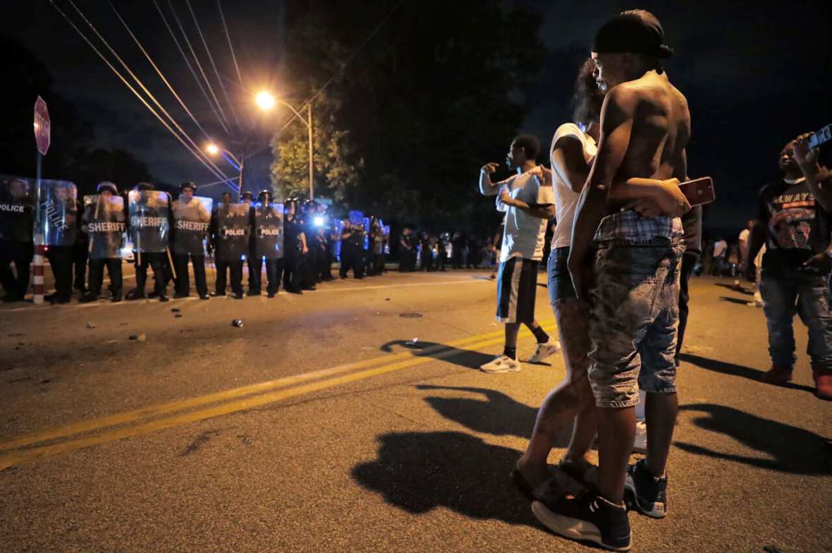 A man identified as Sonny Webber, right, father of Brandon Webber who was reportedly shot by U.S. Marshals earlier in the evening, joins a standoff as protesters take to the streets of the Frayser community in anger against the shooting, Wednesday, June 12, 2019, in Memphis, Tenn. (Jim Weber/Daily Memphian via AP)