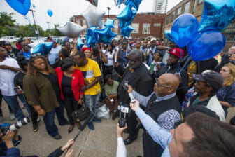Guests gather and listen to community leaders speak during a vigil for Eric Logan Monday, June 17, 2019 on Washington Street in South Bend, Ind. Logan, 54, was killed in South Bend early Sunday after someone called police to report a suspicious person going through cars, according to the St. Joseph County prosecutor's office. (Michael Caterina/South Bend Tribune via AP)