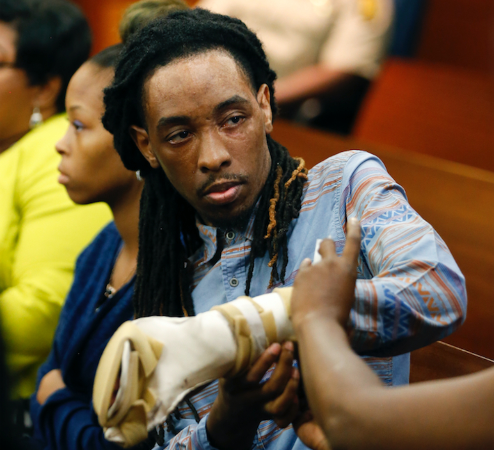 In this Aug. 24, 2016 file photo, burn victim Anthony Gooden gets help with his injured hand during a break in the trial for Martin Blackwell in Atlanta. Blackwell, who was convicted of throwing scalding water on a Gooden and his boyfriend while they slept, told one of them to “get out of my house with all that gay,” a victim testified, but he couldn’t be charged with a hate crime because the state has no such law. Georgia is one of only four states - along with South Carolina, Wyoming and Arkansas - without an official hate crimes law. (AP Photo/John Bazemore, File)