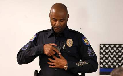 Phoenix Police Department Sgt. Kevin Johnson demonstrates the new Axon Body 2 body camera to fellow officers as another precinct gets their cameras assigned to them Wednesday, July 3, 2019, in Phoenix. Although body-worn cameras are becoming a police standard nationwide, Phoenix was among the last big departments to adopt their widespread use. (AP Photo/Ross D. Franklin)