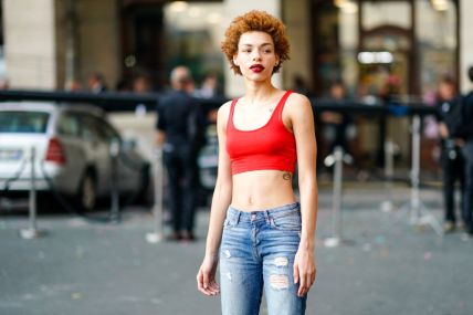 Model Carissa Pinkston wears red bra top, ripped blue denim jeans, white sneakers , outside the Miu Miu Cruise Collection show, outside the Hotel Regina, in Paris, on June 30, 2018 in Paris, France. (Photo by Edward Berthelot/Getty Images)