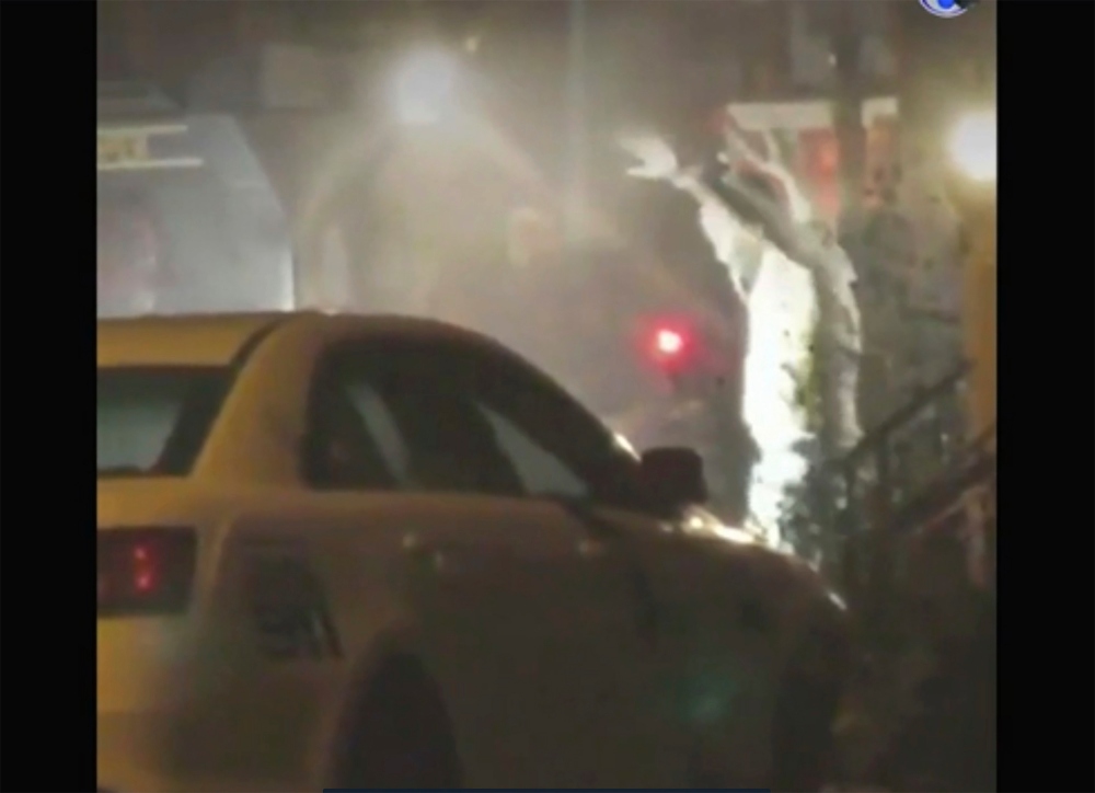In this image from video taken by Bill Trenwith on Wednesday, Aug. 14, 2019, a man exits a building with hands up in Philadelphia, Pennsylvania. A gunman who opened fire on police Wednesday as they were serving a drug warrant in Philadelphia, wounding six officers and triggering a standoff that extended into the night, is in police custody, authorities said. (Bill Trenwith via AP) thegrio.com