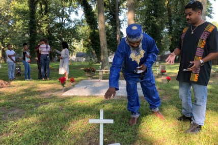 Andre Bradshaw, left, and Eric Jackson stand at an unmarked grave at the Tucker Family Cemetery in Hampton, Va. on Friday, Aug. 23, 2019. They are part of a larger family that traces its roots back to the first enslaved Africans to arrive in what is now Virginia in 1619. (AP Photo/Ben Finley) thegrio.com