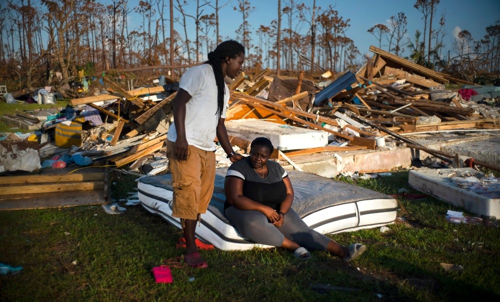 Synobia Reckley pauses on a wet mattress as her husband Dexter Edwards consoles her amid the remains of their home destroyed by Hurricane Dorian in Rocky Creek East End, Grand Bahama, Bahamas, Sunday, Sept. 8, 2019. The couple married two days after Hurricane Mathew hit in 2016 but did not do serious damage. (AP Photo/Ramon Espinosa) thegrio.com