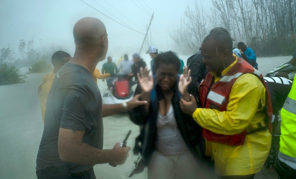 Volunteers rescue several families that arrived on small boats, from the rising waters of Hurricane Dorian, near the Causarina bridge in Freeport, Grand Bahama, Bahamas, Tuesday, Sept. 3, 2019. The storm’s punishing winds and muddy brown floodwaters devastated thousands of homes, crippled hospitals and trapped people in attics. (AP Photo/Ramon Espinosa) thegrio.com