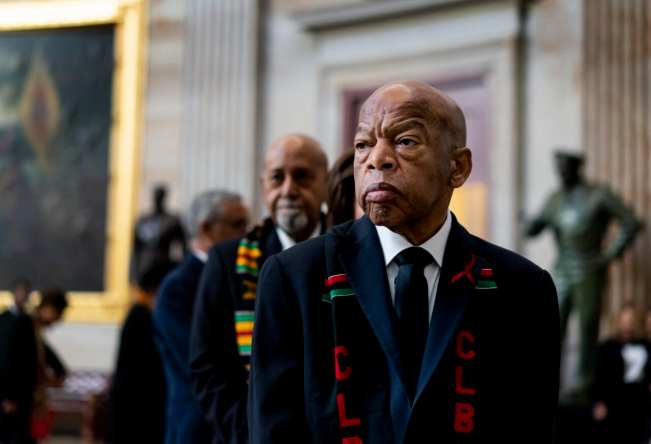 Rep. John Lewis stands solemnly, preparing to pay his respects to Rep. Elijah Cummings during a memorial ceremony in the Capitol's Statuary Hall in 2019.
