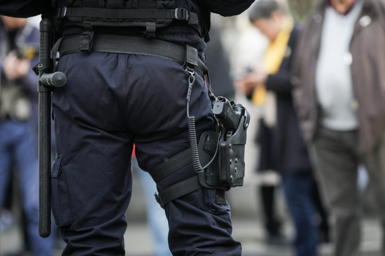 Details of the security kit of a riot police officer (including handcuffs, 9mm handgun, radio station and baton)