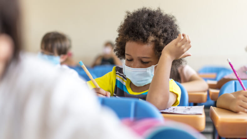 Black chool boy wearing mask and study in classroom