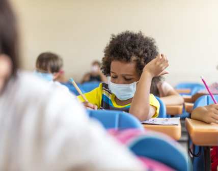 Black chool boy wearing mask and study in classroom