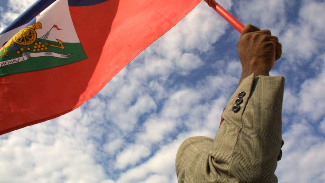 A man holds a Haitian flag