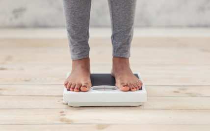 Black woman steps on weighing scale thegrio.com