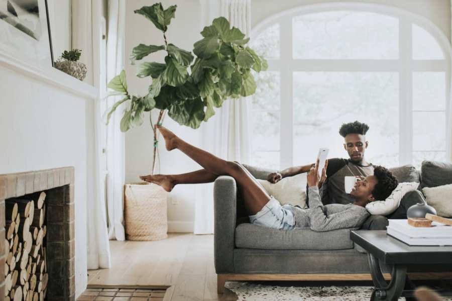 Black couple reading a book on the couch