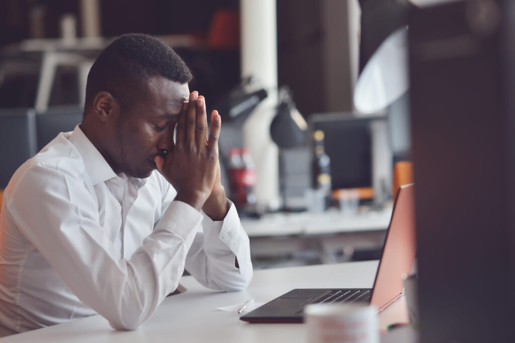 Black man stressed at office, theGrio.com