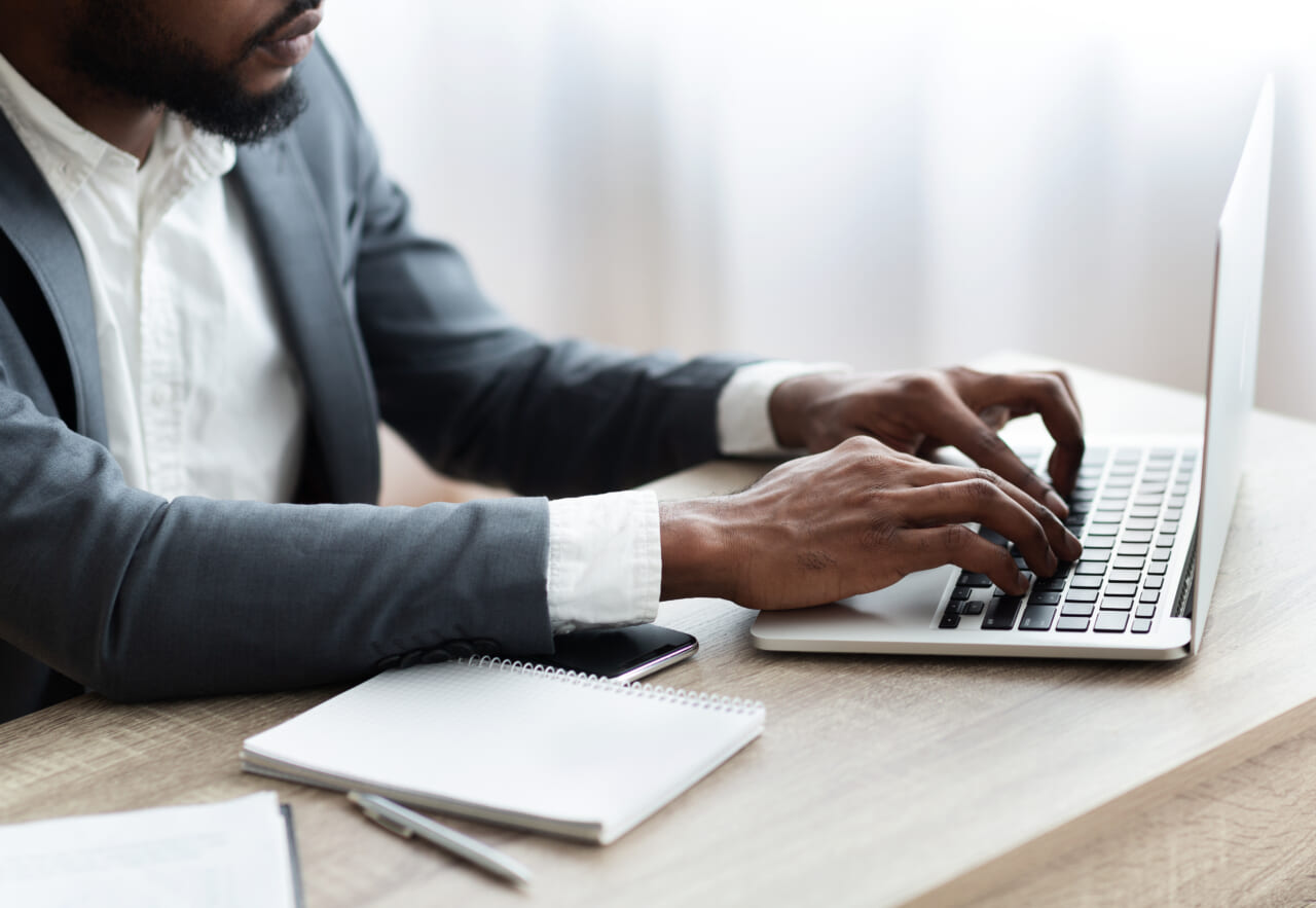 Black man in suit works on computer