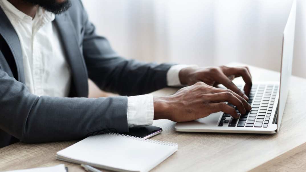 Black man in suit works on computer