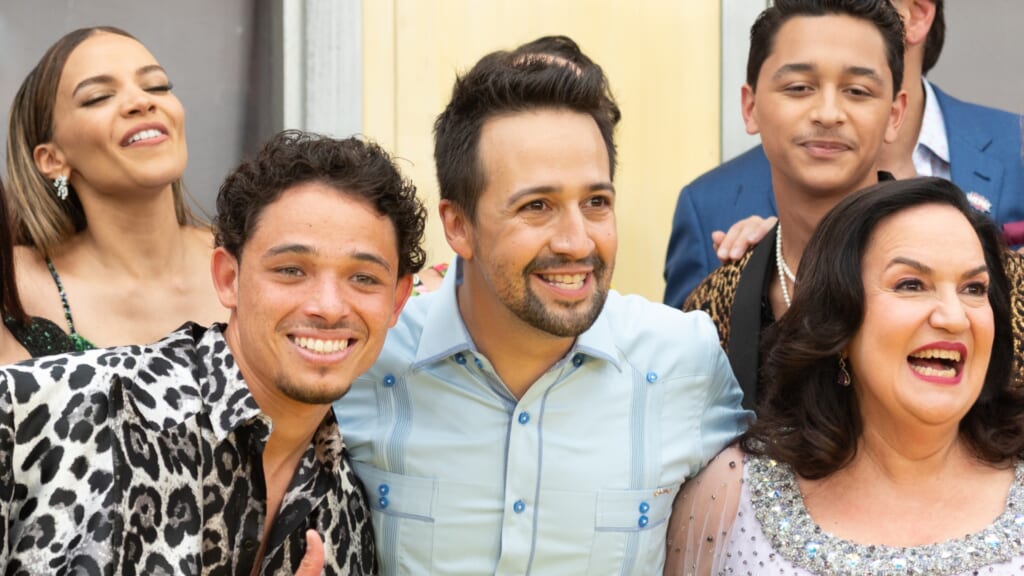 Actor and producer Lin-Manuel Miranda wearing a light blue shirt, surrounded by cast members and friends