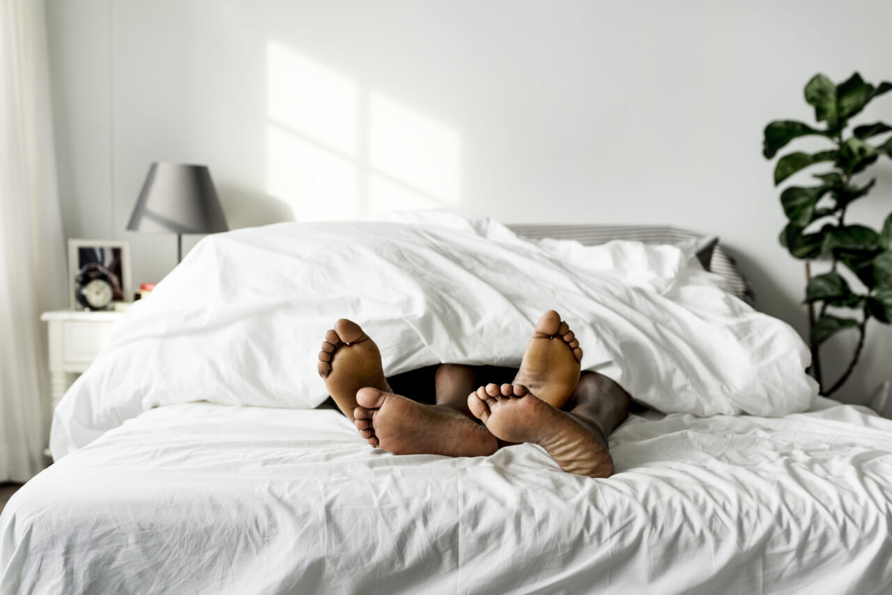 Black couple lying on bed together